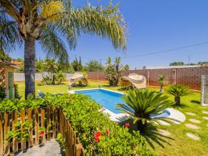 un patio trasero con una piscina y una palmera en Cubo's Villa Lula, en Cártama