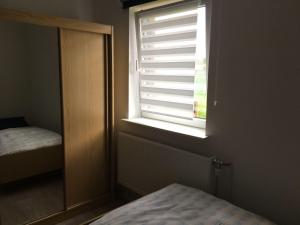 a window in a room with a bed and a mirror at Haselnuss in Nahrendorf