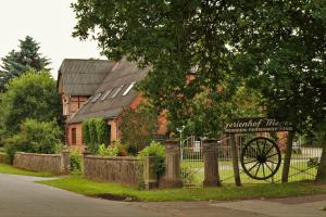 a house with a sign in front of a fence at Haselnuss in Nahrendorf