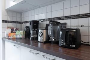 a kitchen counter with a coffee maker and a blender at Balcony Apartment, 1 min to U1 Reumannplatz in Vienna