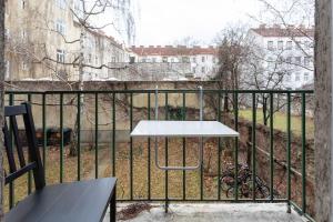a table on a balcony with a fence at Balcony Apartment, 1 min to U1 Reumannplatz in Vienna
