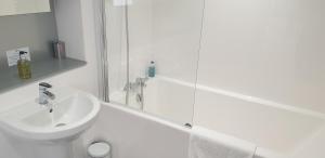 a white bathroom with a sink and a shower at Quay Apartments Exchange Quay in Manchester