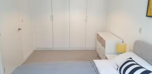 a white bed in a room with a white wall at Quay Apartments Exchange Quay in Manchester