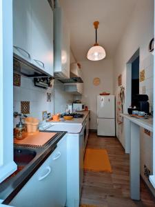 eine Küche mit weißen Arbeitsflächen und einem weißen Kühlschrank in der Unterkunft Casa Vacanza Due Elle - Casa Margherita in Triest