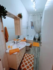 ein Badezimmer mit einem Waschbecken, einem WC und einem Spiegel in der Unterkunft Casa Vacanza Due Elle - Casa Margherita in Triest