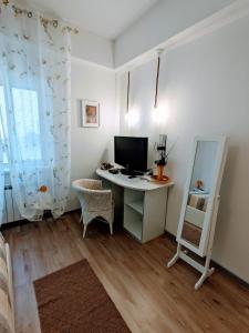 Zimmer mit einem Schreibtisch, einem Computer und einem Spiegel in der Unterkunft Casa Vacanza Due Elle - Casa Margherita in Triest