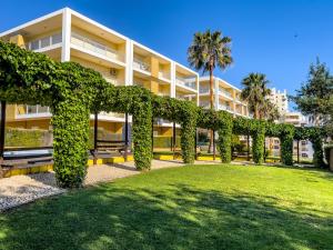 un edificio cubierto de hiedra verde en un parque en Apartamento Vila Arade, en Portimão