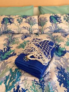 Una cama con un edredón azul y blanco. en Nuccio's house, en Santa Tecla