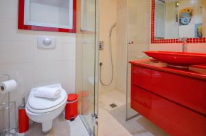 a bathroom with a red sink and a toilet at YalaRent Eucalyptus 2BR & Balcony APT in Eilat