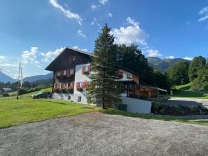 ein großes Haus mit einem Baum davor in der Unterkunft Gasthaus Sulzfluh in Schruns-Tschagguns