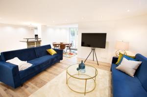 sala de estar con sofá azul y TV en Wohnperle Apartment Alexa, en Dresden