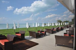 una fila de mesas y sillas con sombrillas blancas en Hotel Európa, en Siófok