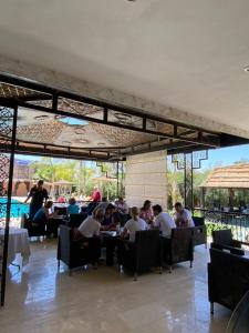 a group of people sitting at tables in a restaurant at L'AUBERGE DE TENNIS MSC in Marrakech