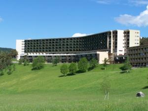 ein großes Gebäude auf einem Hügel mit einem grünen Feld in der Unterkunft Studio Villard-de-Lans, 1 pièce, 4 personnes - FR-1-515-42 in Villard-de-Lans