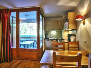 eine Küche und ein Esszimmer mit einem Holztisch und Stühlen in der Unterkunft Studio Brides-les-Bains, 1 pièce, 4 personnes - FR-1-512-49 in Brides-les-Bains