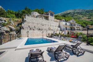 a villa with a swimming pool in front of a building at VILLA MILENA in Kotor