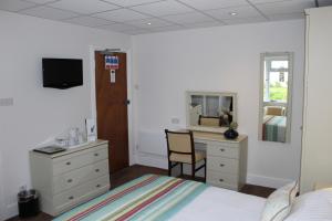 a bedroom with a bed and a desk at Westhill Country Hotel in Saint Helier Jersey
