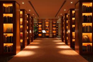 a library with bookshelves and a long hallway at Park Hyatt Tokyo in Tokyo