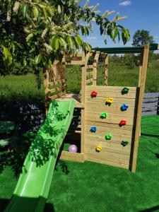 a wooden playset with a slide and a playground at M&M House in Okuninka