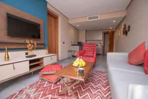 Address Hotel Casablanca في الدار البيضاء: غرفة معيشة مع أريكة وتلفزيون