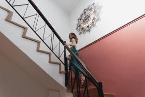 a woman in a green dress walking down the stairs at Bastion Luxury Medieval Accommodation in Rhodes Town