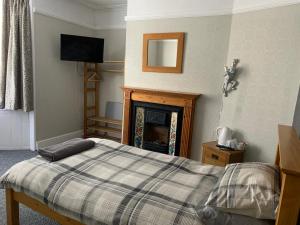 a bedroom with a bed and a fireplace at Bourton House in Rugby