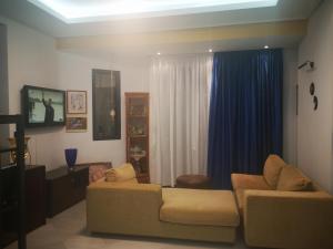 a living room with a couch and blue curtains at Cactus Suite in Prinos