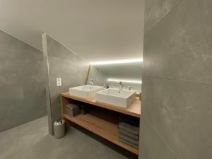 La salle de bains est pourvue de 2 lavabos et d'un miroir. dans l'établissement Gasthaus Sulzfluh, à Schruns