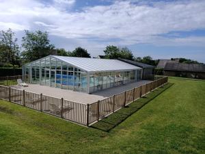 a glass house with a pool in a field at VVF Normandie Veules-les-Roses in Veules-les-Roses