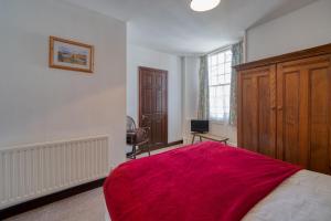 a bedroom with a bed with a red blanket at The George and Dragon in Dent