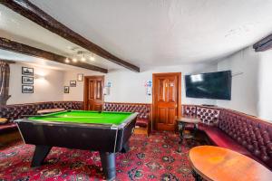 a pool table in a room with leather furniture at George and Dragon Dent in Dent