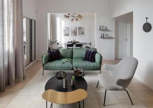 uma sala de estar com um sofá verde e uma mesa em BB Hotels Aparthotel Collection Il Michelangelo em Florença