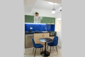 uma cozinha com armários azuis e uma mesa e cadeiras em Valory #4 Aesthetic Stay em Tessalônica