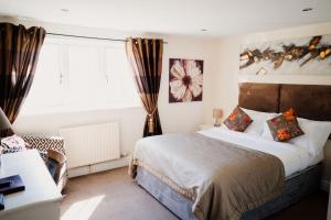 um quarto com uma cama grande e uma janela em The Cricketers Arms em Stansted Mountfitchet