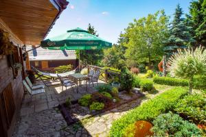a patio with a table and a green umbrella at Chata Na Krańcu Świata in Łączna