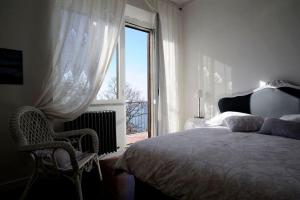 una camera con letto, finestra e sedia di Il Caminetto Montefiascone a Montefiascone