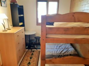 1 dormitorio con 2 literas y escritorio en Appartement Les Deux Alpes, 2 pièces, 4 personnes - FR-1-516-145 en Mont-de-Lans