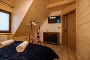 a bedroom with a blue bed in a wooden room at Apartamenty na Polnej in Leśnica