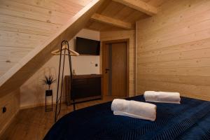 a bedroom with a blue bed with two towels on it at Apartamenty na Polnej in Leśnica