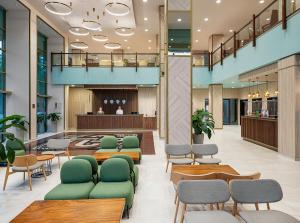 a lobby with green chairs and a waiting area at Melia Sunny Beach All Inclusive in Sunny Beach