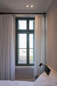 a bedroom with a bed and a large window at Acron Athens in Athens
