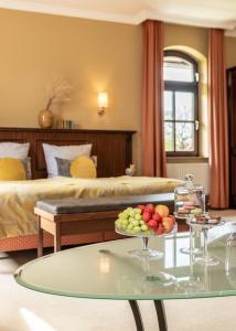 ein Zimmer mit einem Bett und einem Tisch mit Obst darauf in der Unterkunft LandHaus Zum LindenHof in Marxen