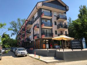 duży budynek apartamentowy z znakiem przed nim w obiekcie Apartman Pino w mieście Veliko Gradište