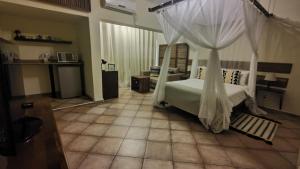 a bedroom with a bed with a canopy at Sundown Guest House Maputo in Maputo