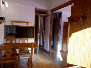ein Esszimmer mit einem Tisch und einem TV in der Unterkunft Appartement Méribel, 1 pièce, 4 personnes - FR-1-355-178 in Méribel