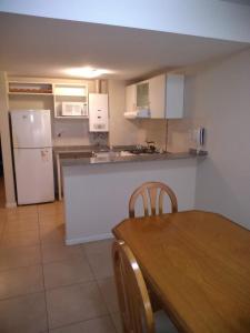 a kitchen with a table and a white refrigerator at Cerrito 1326 Apartamento in Rosario