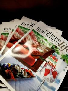 a table topped with magazines and a glass of wine at Casa Dorita - Free Coffee Corner 8-12 in Cervia +95 photos
