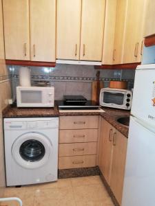 a kitchen with a washing machine and a microwave at La Mata & Sea in La Mata