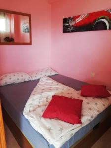 ラ・マタにあるLa Mata & Seaの赤い枕2つが付いたベッド1台