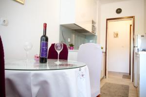 a table with a bottle of wine and two glasses at Apartman Alka in Sinj